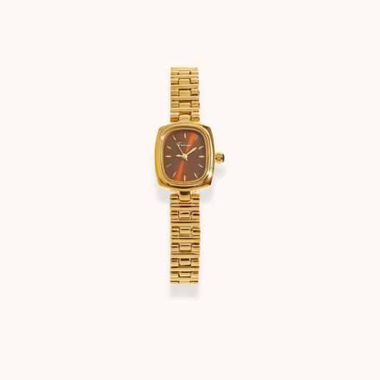 Gold wristwatch with a brown face on a white background