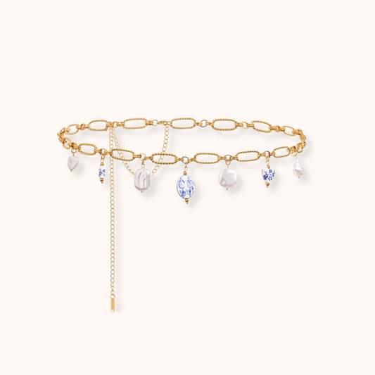 Gold charm waist chain with pearls and ocean-themed drops on adjustable stainless steel links.