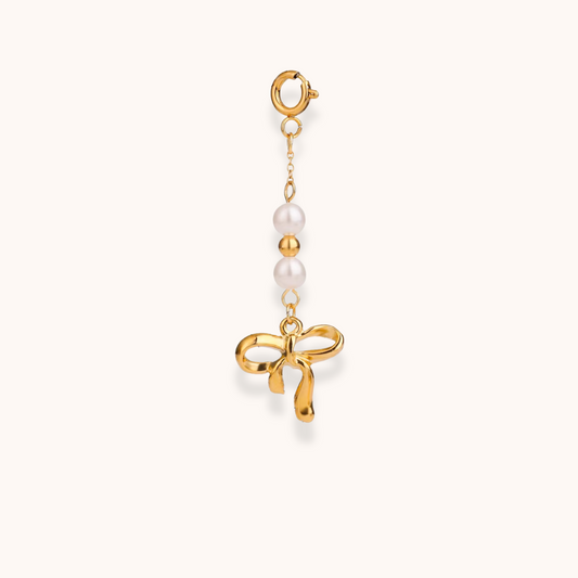 Gold ribbon charm with pearl detail and lobster clasp – part of Aurelia Glamour’s Golden Charm Collection