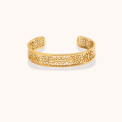 Gold bracelet with intricate design on a white background